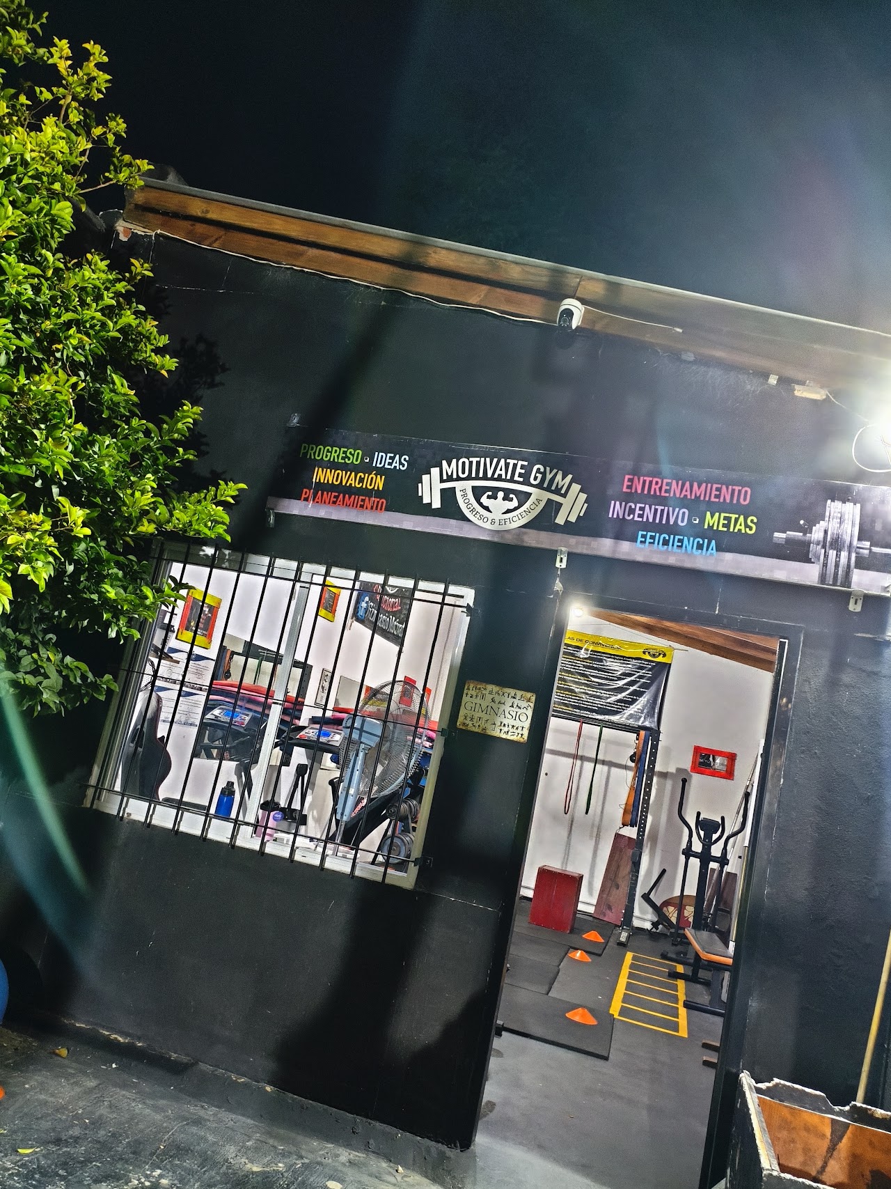 Fachada boutique de Motivate Gym en Temperley con iluminación dorada nocturna